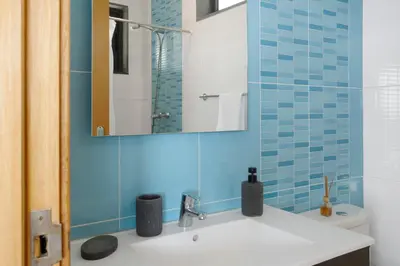 a bathroom with a sink and a mirror and a toilet at Original Wave House in Jardim do Mar