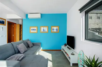 a living room with a couch and a blue wall at The Wave House - Two Bedroom Flat in Jardim do Mar