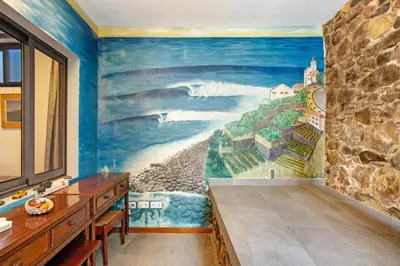 a balcony with tables and chairs and the ocean at The Wave House - Two Bedroom Flat in Jardim do Mar
