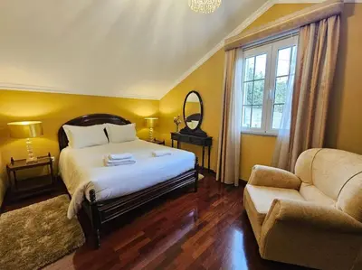 a bedroom with a bed and a couch and a mirror at Villa River Ponta do Sol by Rentallido in Canhas