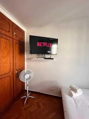 a television on a wall in a room with a couch at Casa Valhalla in Funchal