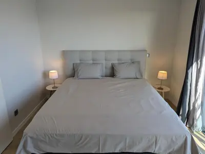 a bedroom with a large white bed with two lamps at Top-Floor One-Bedroom Flats - Peaceful with Ocean and City Views in Funchal