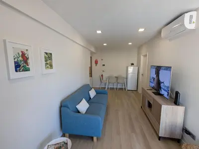 a living room with a blue couch and a flat screen tv at Top-Floor One-Bedroom Flats - Peaceful with Ocean and City Views in Funchal
