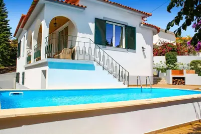 a villa with a swimming pool in front of a house at Villa Casa Amelia by Villa Plus in Caniço