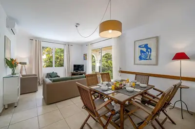a dining room and living room with a table and chairs at Villa Casa Amelia by Villa Plus in Caniço