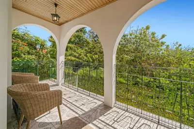 an outdoor patio with chairs and a balcony at Villa Casa Amelia by Villa Plus in Caniço
