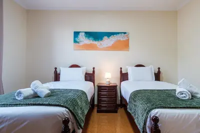 a bedroom with two twin beds and a night stand at GuestReady - A charming experience in Madeira in Machico