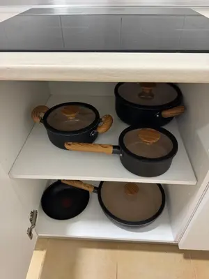 a drawer filled with pots and pans on a shelf at Alforra Residence 2-Centro-Praias-Levadas in Câmara de Lobos