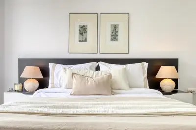 a bedroom with a large white bed with two lamps at Ribas Machico, a Home in Madeira in Machico