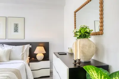 a bedroom with a bed and a table with a vase of flowers at Ribas Machico, a Home in Madeira in Machico