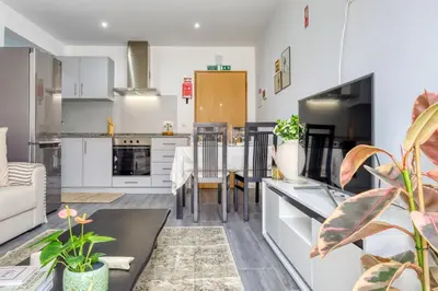 a kitchen with white cabinets and a table and chairs at Ribas Machico, a Home in Madeira in Machico