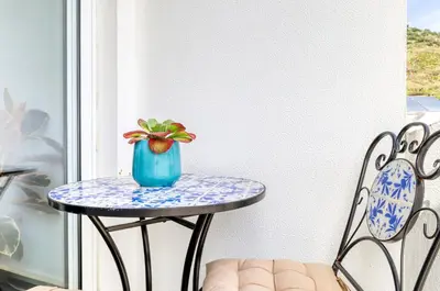 a blue vase sitting on a table on a porch at Ribas Machico, a Home in Madeira in Machico