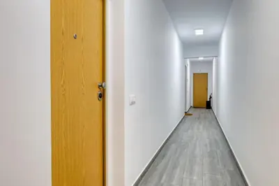 a hallway with white walls and a wooden door at Ribas Machico, a Home in Madeira in Machico