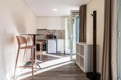 a kitchen with white cabinets and a table and chairs at Terrace in Carmo in Funchal