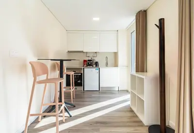 a kitchen with white cabinets and a table and chairs at Terrace in Carmo in Funchal
