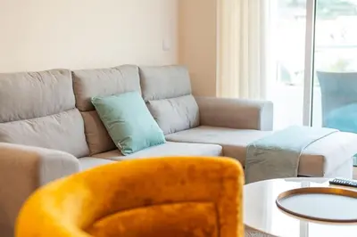 a living room with a couch and a chair at Lux Girassol - Two Bedroom Apartment in Caniço