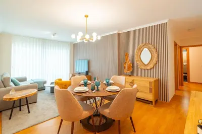 a living room with a table and chairs and a couch at Lux Girassol - Two Bedroom Apartment in Caniço