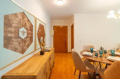 a dining room with a wooden table and a table and chairs at Lux Girassol - Two Bedroom Apartment in Caniço