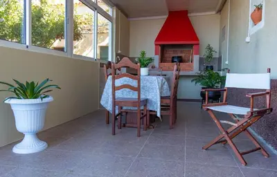 a dining room with a table and chairs and a fireplace at Casa do Prendinha B in Ponta do Pargo