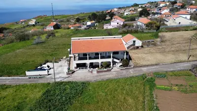 a house with an orange roof on a hill at Casa do Prendinha B in Ponta do Pargo