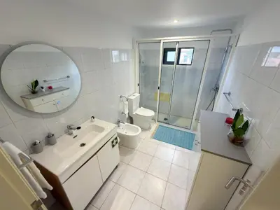 a bathroom with a sink and a toilet and a mirror at Vivenda Silva in Seixal