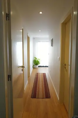 a hallway with a door and a rug on the floor at Vivenda Silva in Seixal