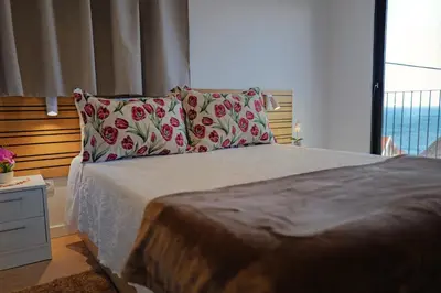 a bedroom with a bed with two pillows and a window at Vivenda Silva in Seixal