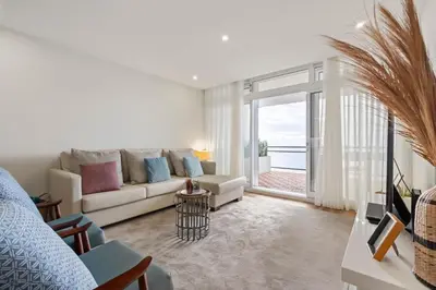 a living room with a couch and a large window at Sunset Vista 604 in Funchal