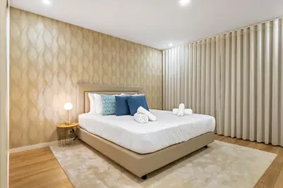 a bedroom with a large white bed with blue pillows at Sunset Vista 604 in Funchal