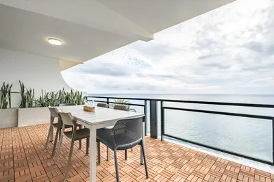 a balcony with a table and chairs and the ocean at Sunset Vista 604 in Funchal