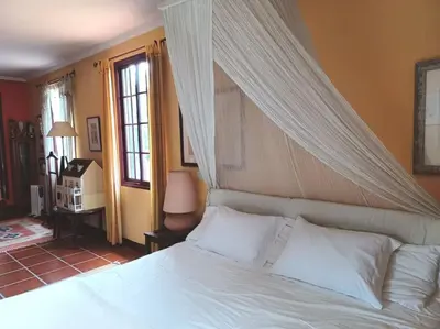 a bedroom with a white bed with a canopy at Casa da Lagoa BB or HB options in Santana