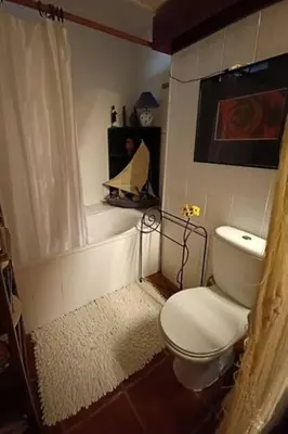 a bathroom with a toilet and a bath tub at Casa da Lagoa BB or HB options in Santana