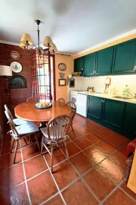 a kitchen with a table and chairs and a kitchen with green cabinets at Casa da Lagoa BB or HB options in Santana