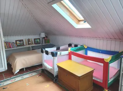 a attic bedroom with a bed and a window at Casa da Lagoa BB or HB options in Santana