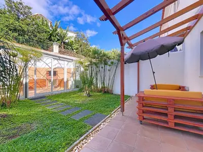 a patio with a bench and an umbrella at Eddys House by Atlantic Holiday in Água de Pena