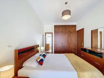 a bedroom with a large bed with a wooden headboard at Eddys House by Atlantic Holiday in Água de Pena