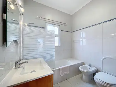 a white bathroom with a sink and a toilet at Eddys House by Atlantic Holiday in Água de Pena