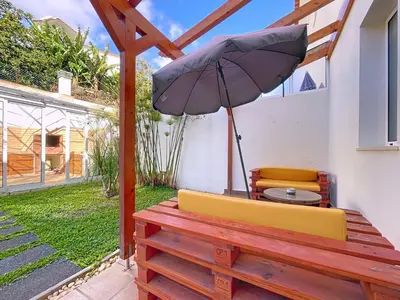 a patio with an umbrella and two chairs and a table at Eddys House by Atlantic Holiday in Água de Pena