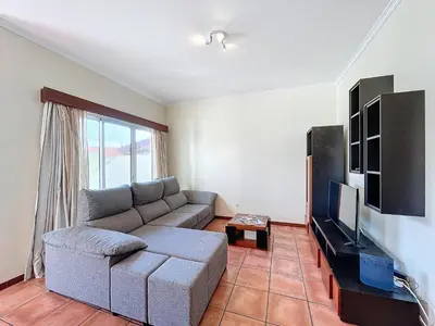 a living room with a couch and a flat screen tv at Eddys House by Atlantic Holiday in Água de Pena