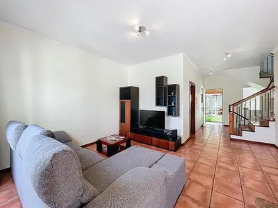 a living room with a couch and a tv at Eddys House by Atlantic Holiday in Água de Pena