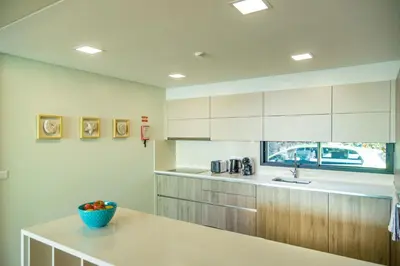 a kitchen with white cabinets and a bowl of fruit on a counter at Villa Eden Sky in Prazeres in Prazeres