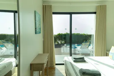 a bedroom with two beds and a view of a patio at Villa Eden Sky in Prazeres in Prazeres