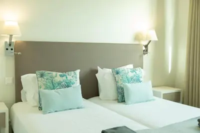 a bedroom with two beds with blue and white pillows at Villa Eden Sky in Prazeres in Prazeres