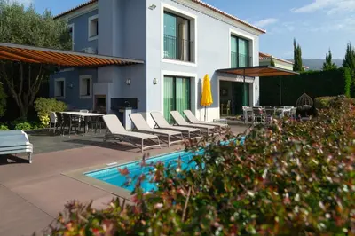 a house with chairs and a pool in front of it at Villa Eden Sky in Prazeres in Prazeres