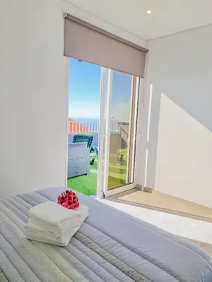 a bedroom with a bed and a large window at Casa Caromba, Sunrise in Prazeres
