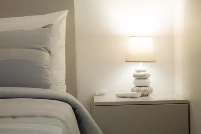 a lamp on a table next to a bed at Casa Caromba, Sunrise in Prazeres