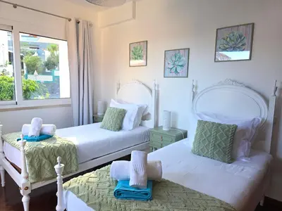two beds in a white bedroom with a window at RODRIGUES ViLLA in Funchal