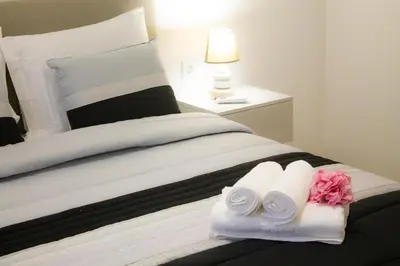 a bedroom with a bed with towels and a lamp at Casa Caromba, Sunset in Prazeres