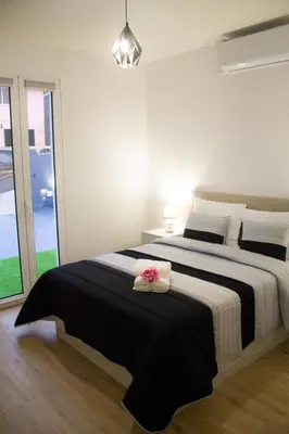a bedroom with a large bed with a black and white blanket at Casa Caromba, Sunset in Prazeres