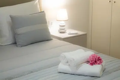 a white bed with a folded towel on it at Casa Caromba, Sunset in Prazeres